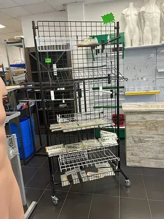 Un maniquí está parado frente a un estante de exhibición en una tienda.