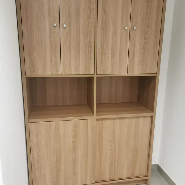 Un armario de madera con puertas y estantes en una habitación.