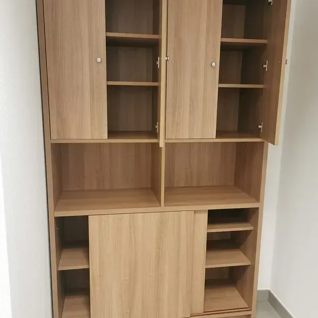 Un armario de madera con las puertas abiertas y estantes.