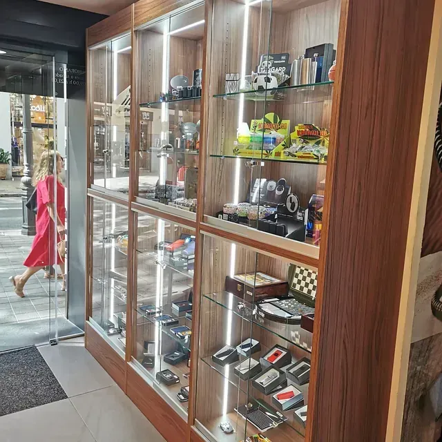 Una mujer con un vestido rojo pasa junto a una vitrina llena de muchos artículos.