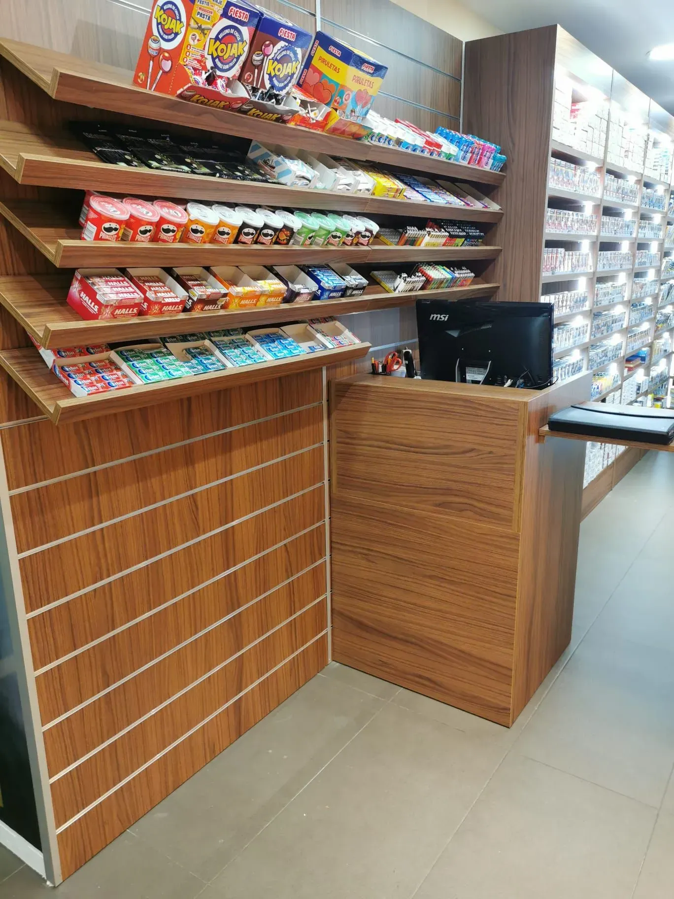 Una tienda de dulces con un mostrador de madera y estantes llenos de dulces.