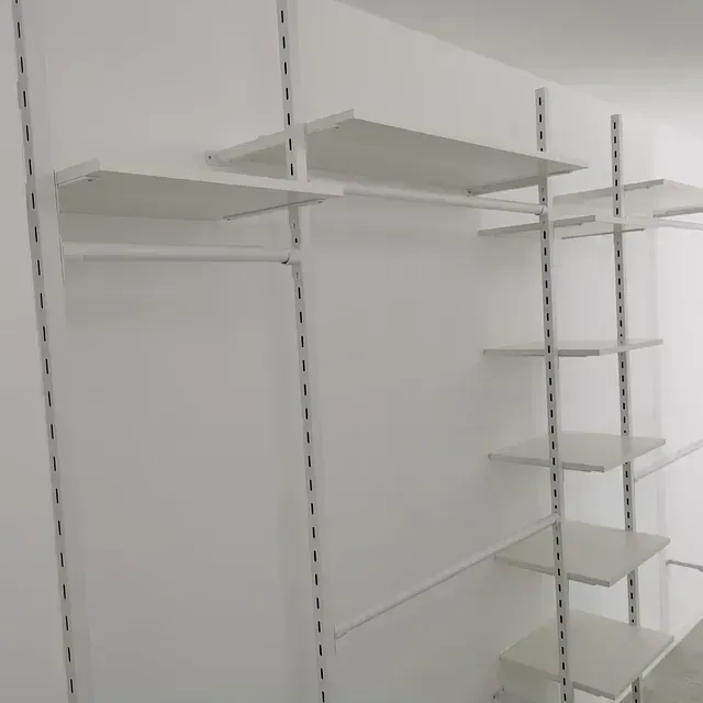 Un armario con estantes blancos y una pared blanca.