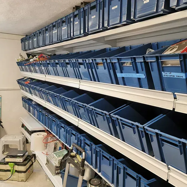 Un estante lleno de contenedores azules con uno que dice 'a' en él