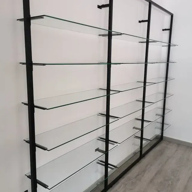 Una fila de estantes de vidrio contra una pared blanca.