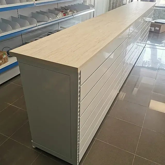 Un mostrador largo blanco con tapa de madera en una tienda.