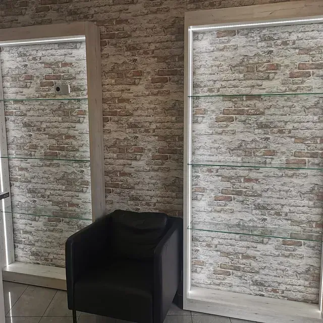 Una silla está sentada frente a una pared de ladrillos.