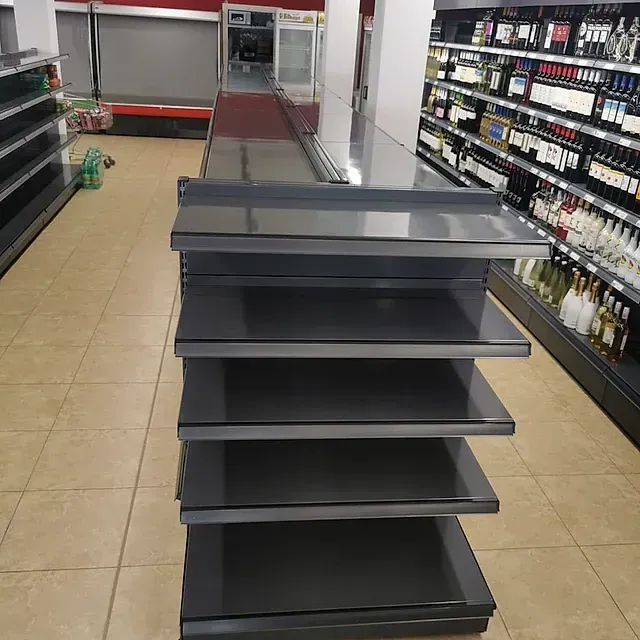 Una fila de estantes vacíos en una tienda de comestibles
