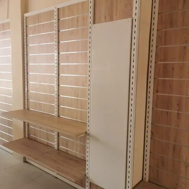 Una pared de madera con estantes y un estante blanco.