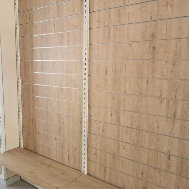 Una pared de madera con un banco delante de ella.