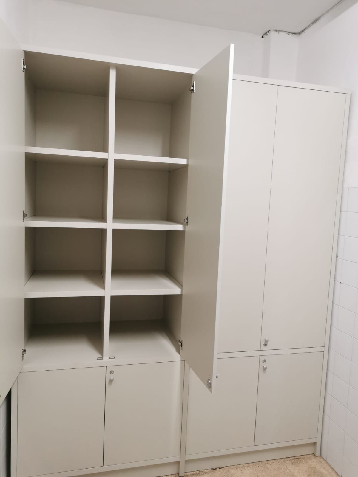 Un armario blanco con la puerta abierta y los estantes vacíos.