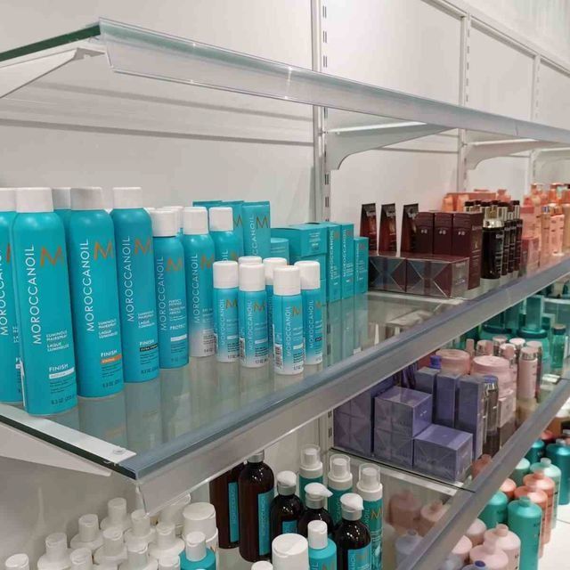 Un estante de tienda lleno de muchos tipos diferentes de cosméticos, incluido Moroccanoil.
