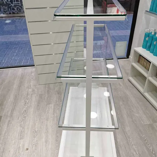 Un estante blanco con estantes de vidrio en una tienda.
