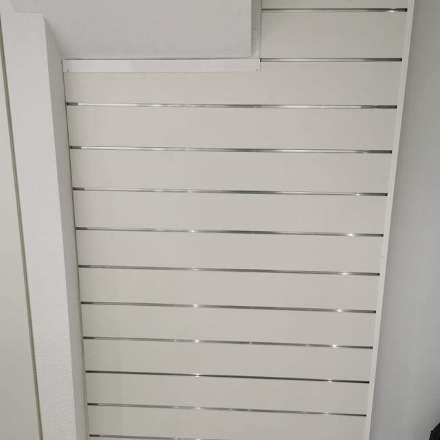 Una pared blanca con rayas plateadas.