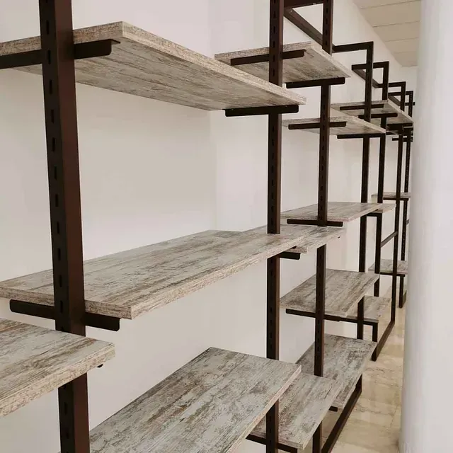 Una fila de estantes de madera contra una pared blanca.