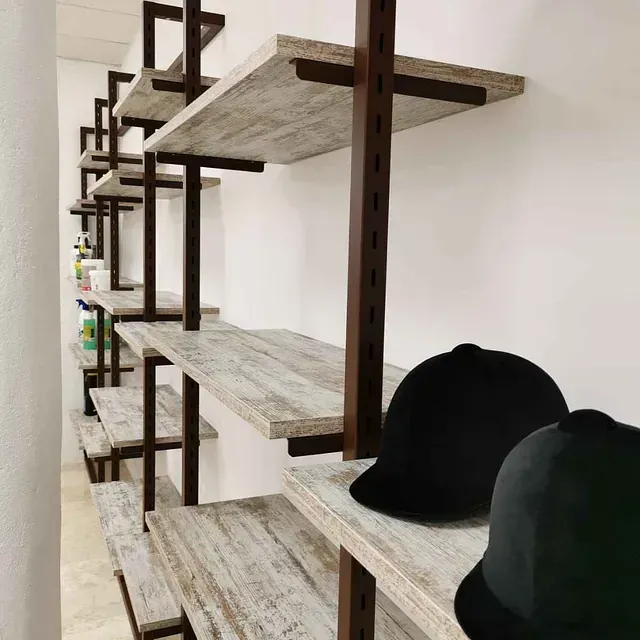 Una fila de estantes con sombreros negros sobre ellos.