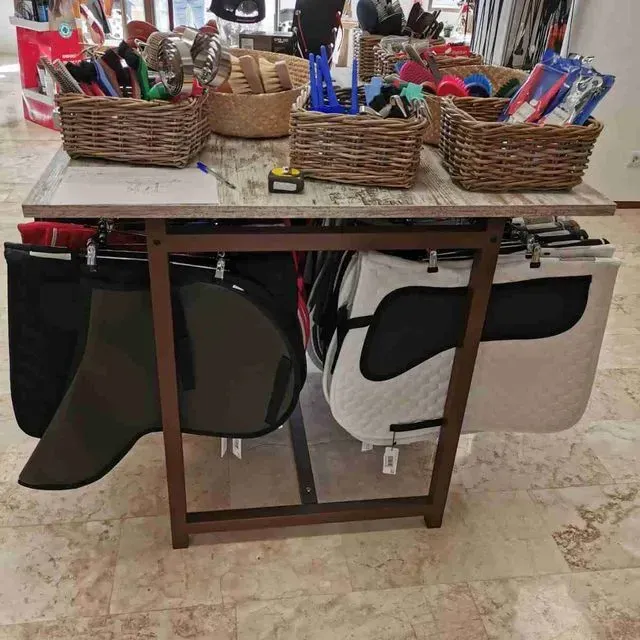 Una mesa con cestas y mantas de silla de montar sobre ella