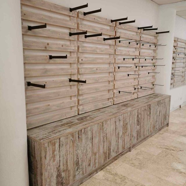 Una pared de madera con muchos estantes y ganchos.