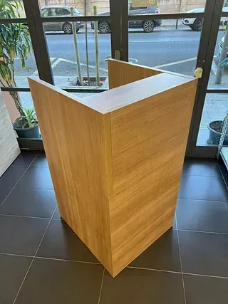 Un podio de madera está colocado sobre un suelo de baldosas frente a una ventana.