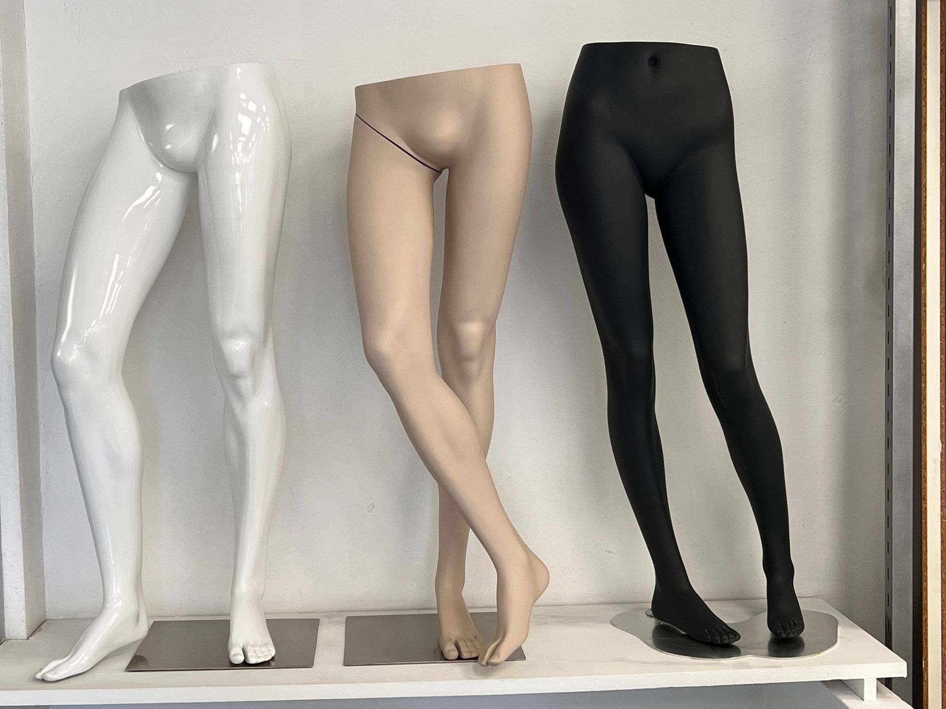 Tres piernas de maniquí están alineadas en un estante