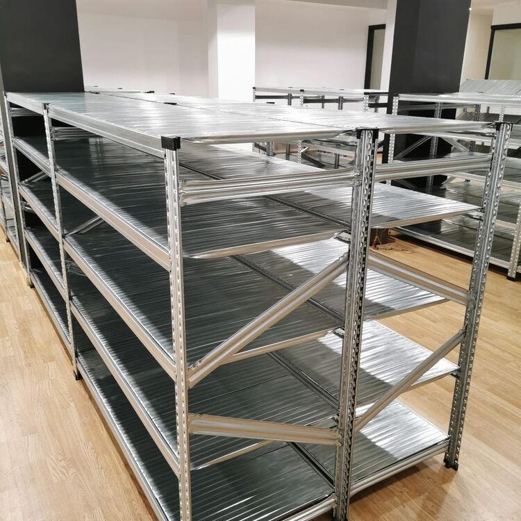 Una fila de estantes de metal en una habitación con pisos de madera.