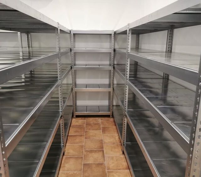 Una habitación con muchos estantes y suelo de baldosas.