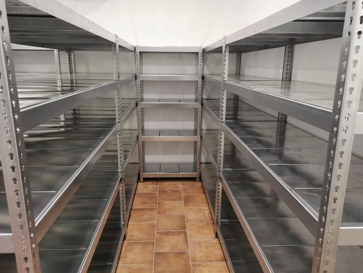 Una habitación con muchos estantes y suelo de baldosas.