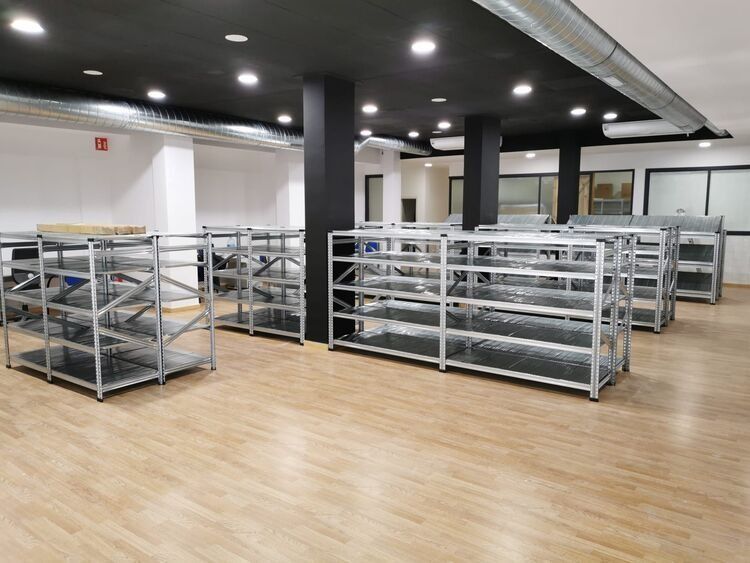 Una habitación grande con muchos estantes y suelo de madera.