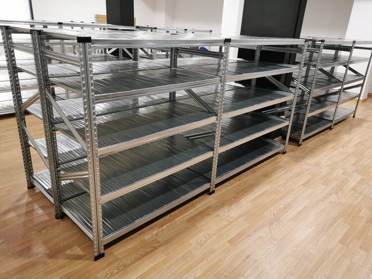 Una fila de estantes de metal colocados encima de un piso de madera.