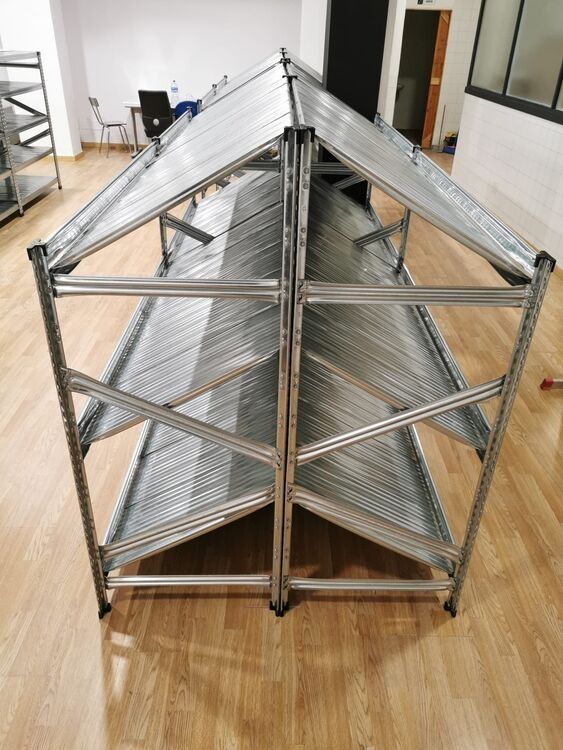 Un estante de metal con techo está colocado sobre un piso de madera en una habitación.