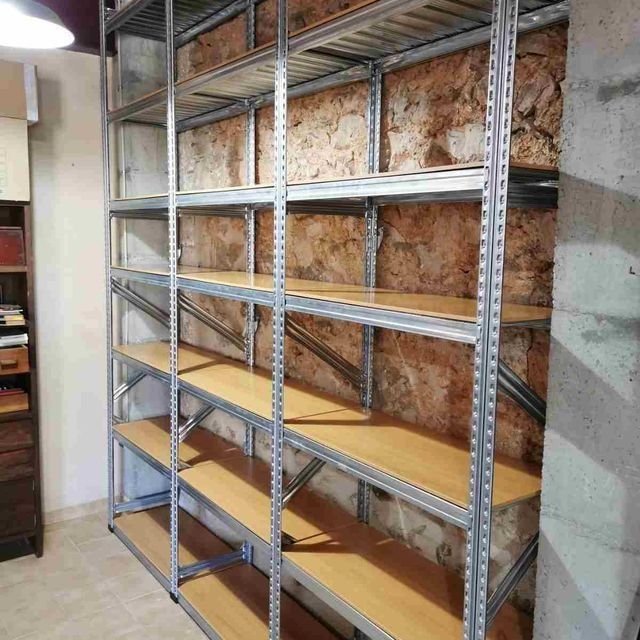 Una fila de estantes de metal con estantes de madera en una habitación.