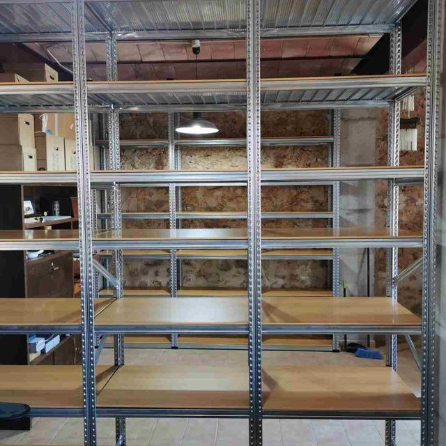 Una fila de estanterías con estantes de madera en una habitación.