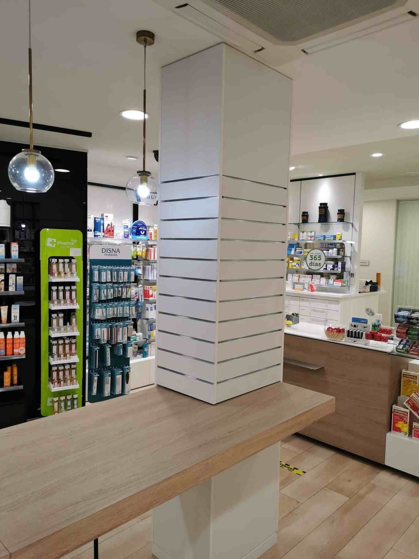 Una farmacia con una mesa de madera y un pilar blanco.