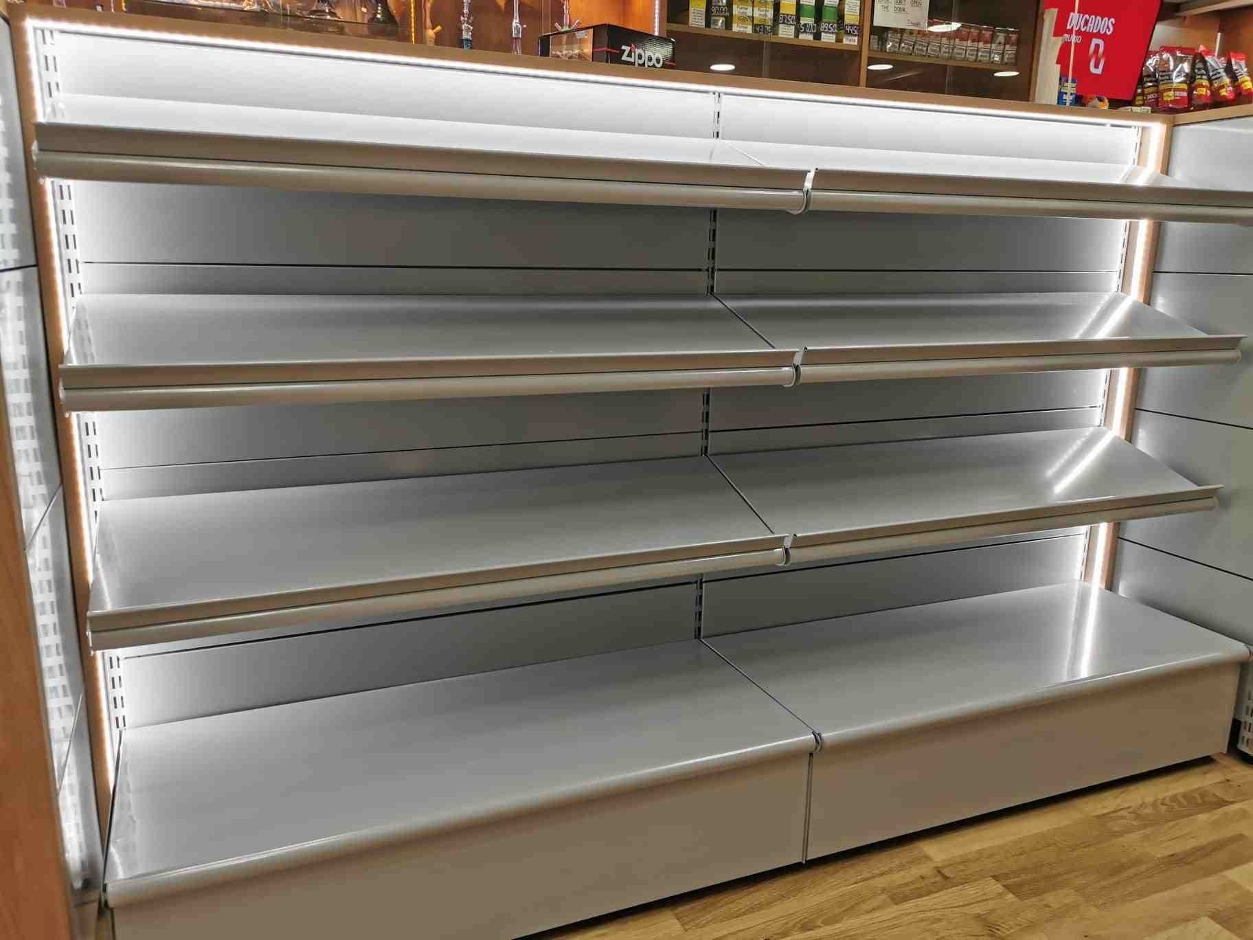 Estantes vacíos en una tienda con luces encendidas.