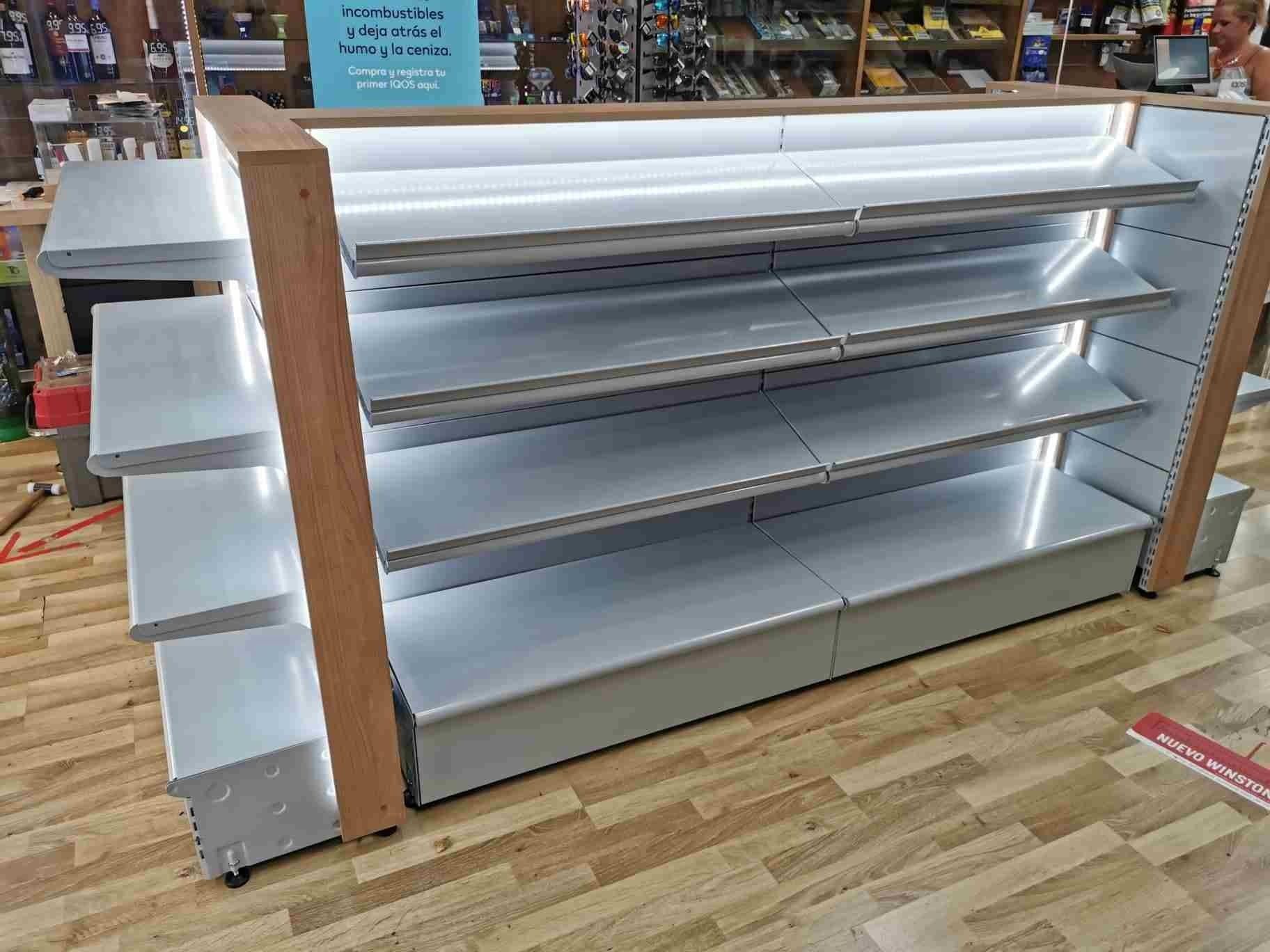 Una fila de estantes vacíos en una tienda con piso de madera.