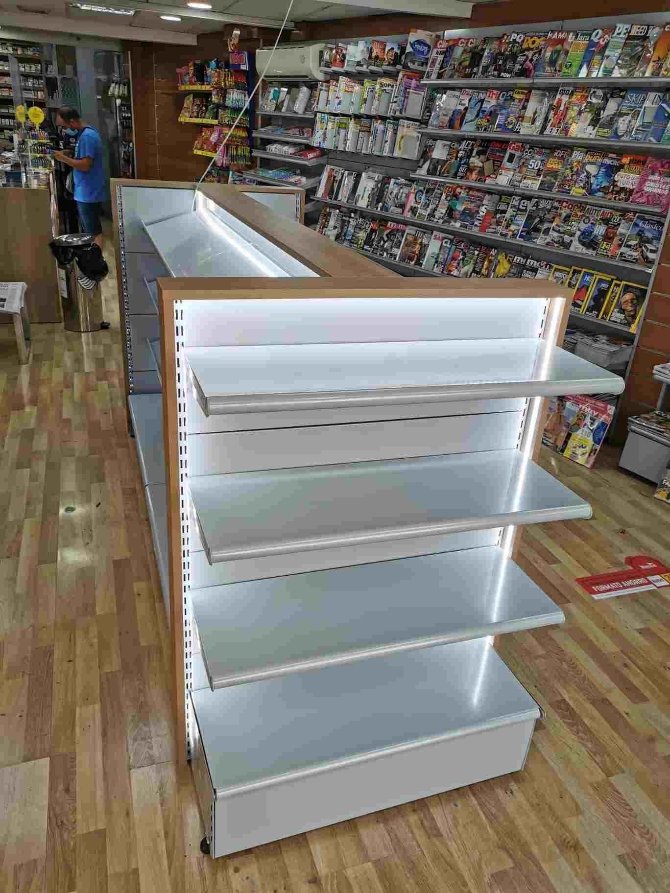 Un hombre está parado frente a una estantería en una tienda.