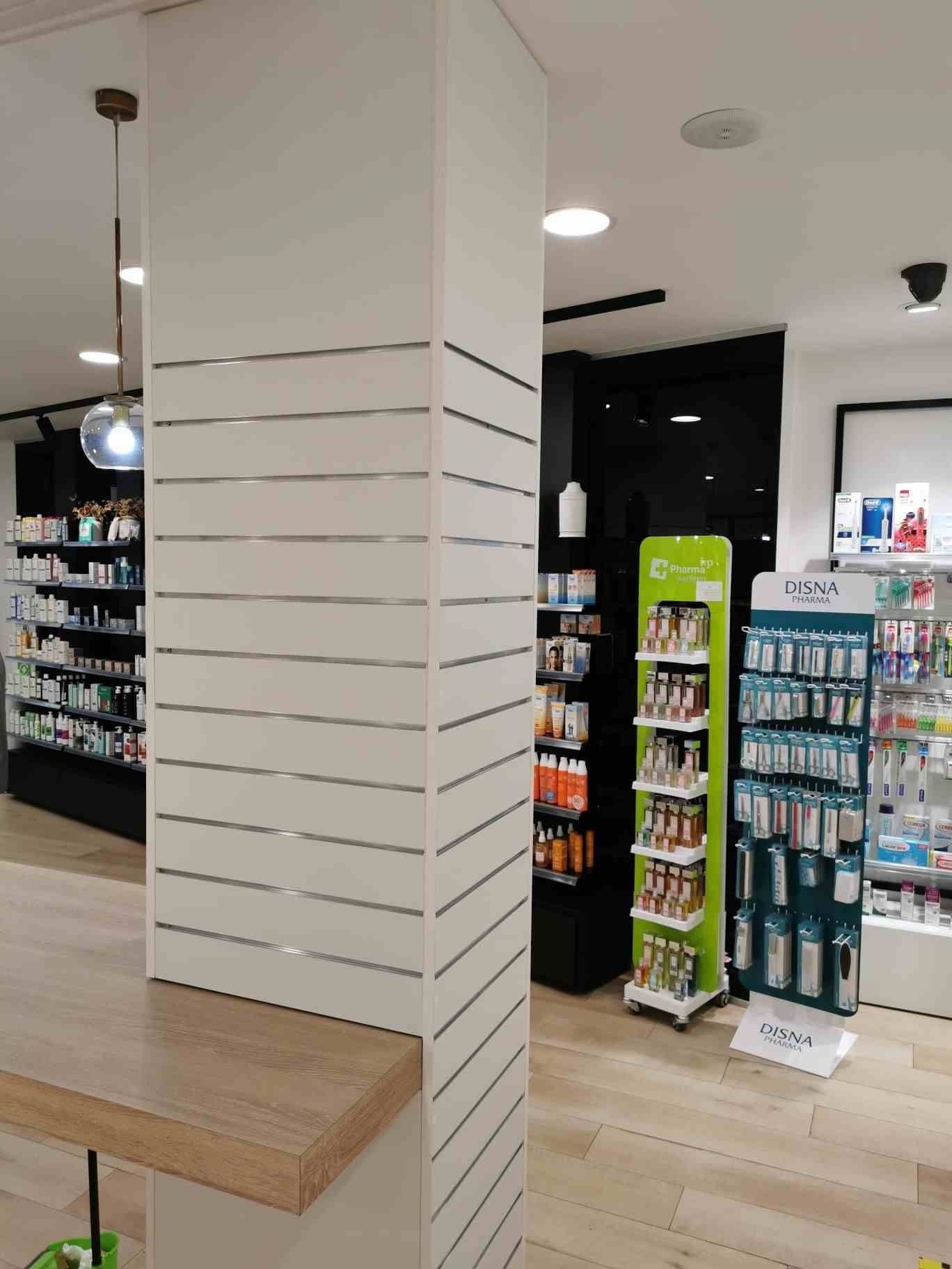 Un rincón de una farmacia con una vitrina verde.