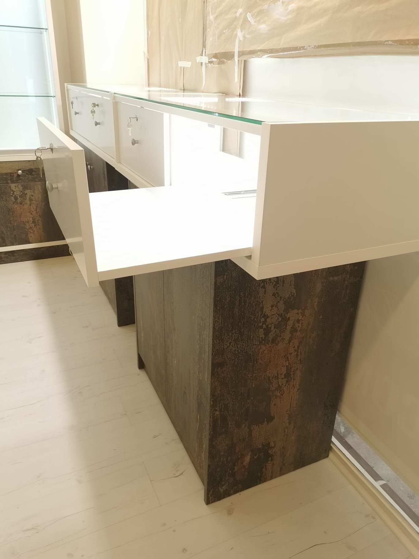 Un tocador de baño con tapa de cristal y cajones.