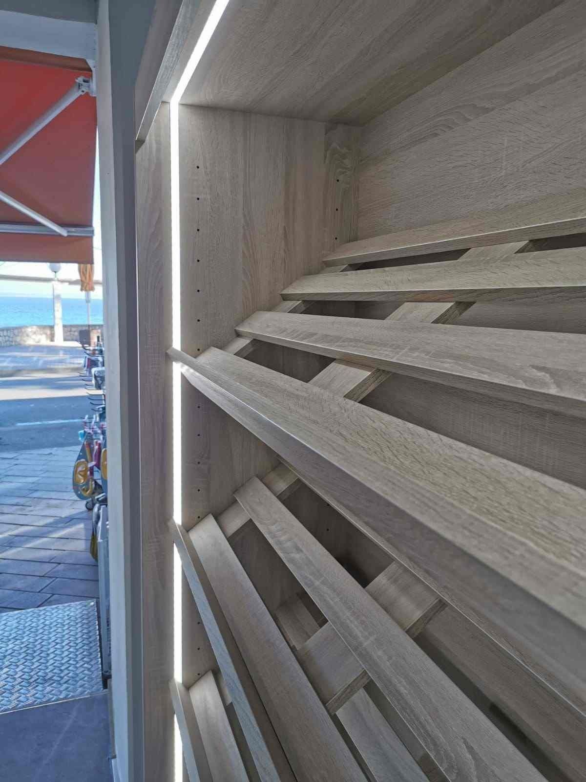 Un estante de madera con una luz en el costado.