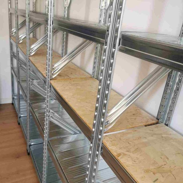 Una fila de estantes de metal con estantes de madera en una habitación.