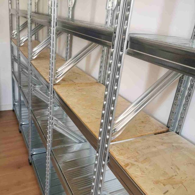 Una fila de estantes de metal con estantes de madera en una habitación.