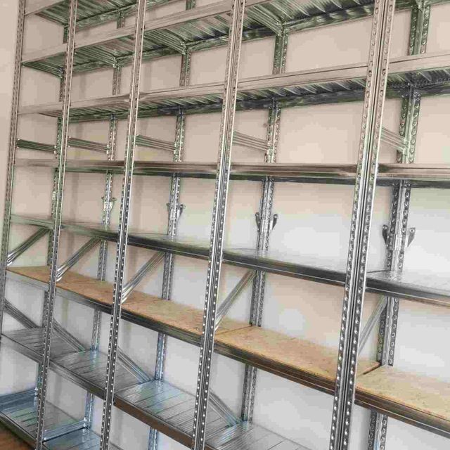 Una fila de estantes de metal con estantes de madera en una habitación.