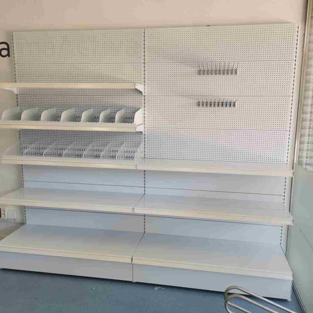 Un estante de tienda vacío con muchos estantes y cajones.