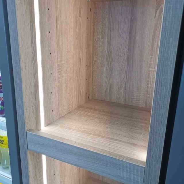 Un primer plano de un estante de madera con una luz encima.