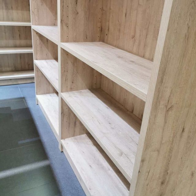 Una fila de estantes de madera vacíos en una habitación.