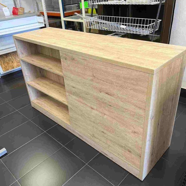 Un mostrador de madera con estantes está colocado sobre un piso de baldosas en una cocina.