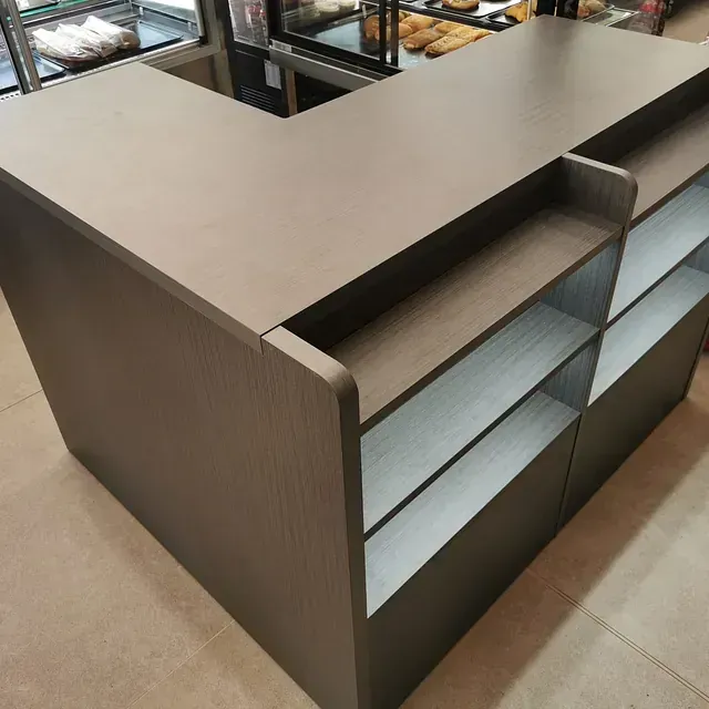 Un mostrador en una panadería con estantes debajo.