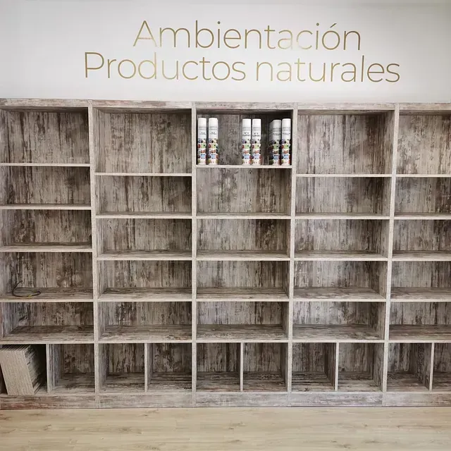 Una fila de estantes de madera con las palabras ambientacion productos naturales en la pared detrás de ellos.