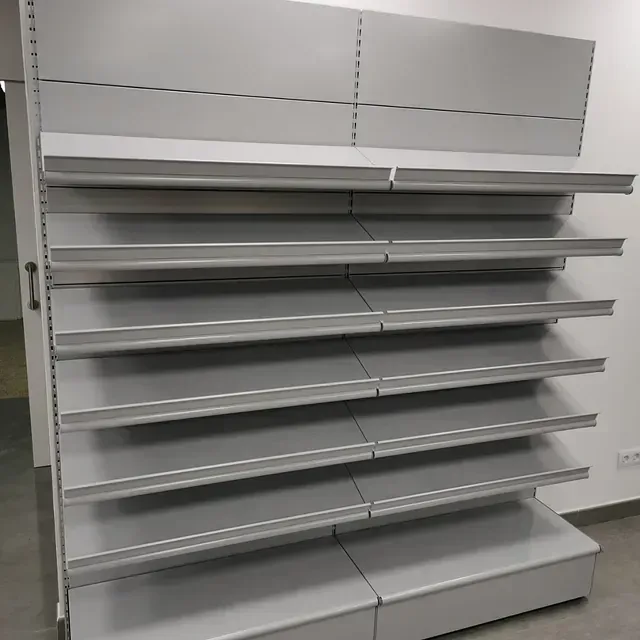 Una fila de estantes vacíos contra una pared blanca