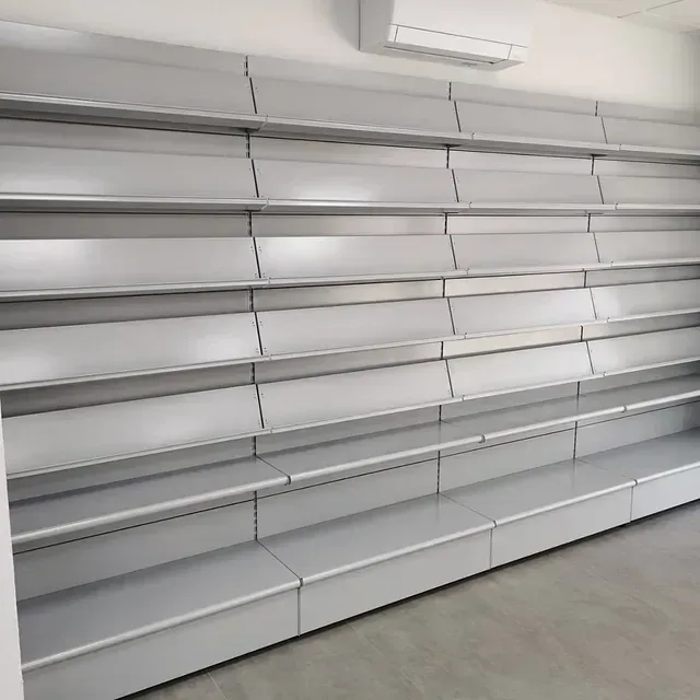 Una fila de estantes vacíos contra una pared en una habitación.