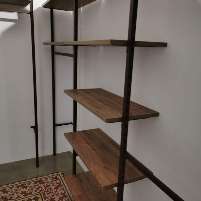 Un armario con estantes de madera y una alfombra.